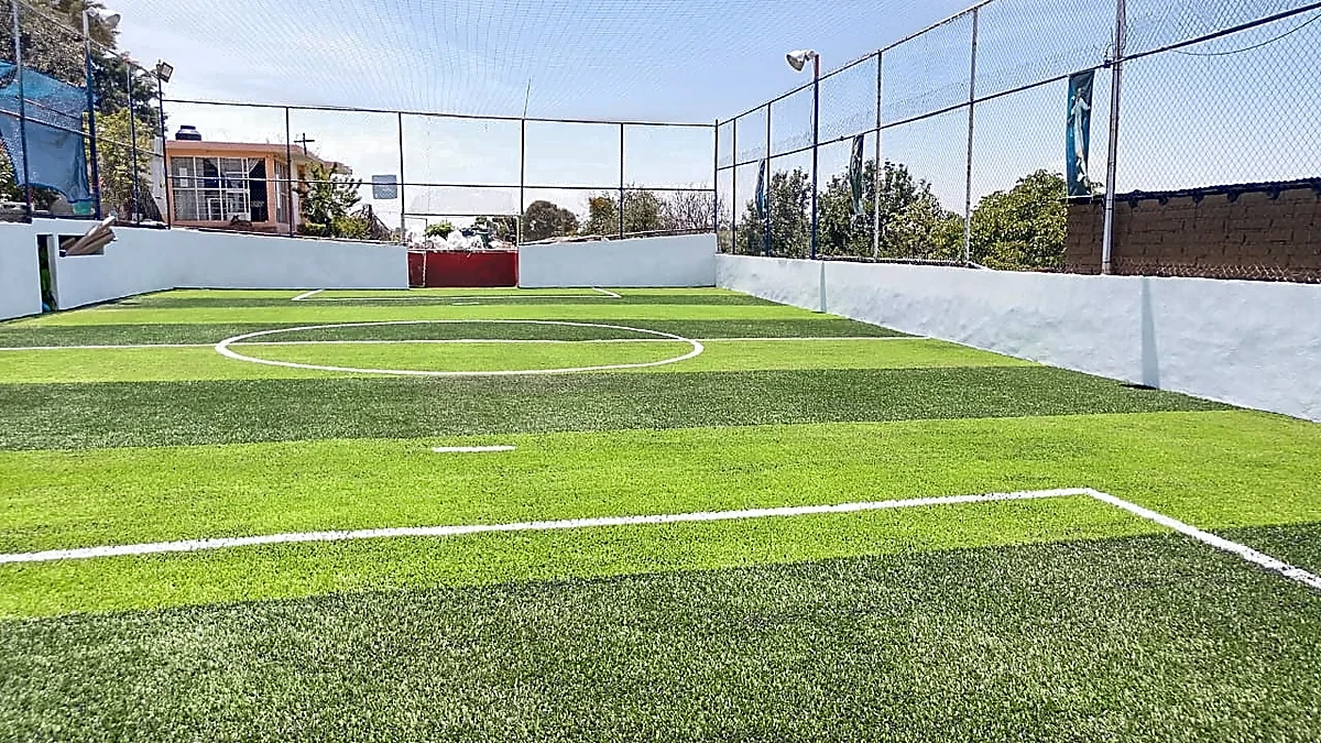 Cancha de fútbol 7 con pasto sintético en Campo Deportivo Titanes de Tlahuapan, Puebla: pasto sintético deportivo recién cepillado