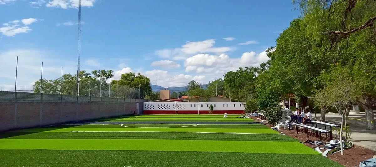 Cancha de fútbol 7 con pasto sintético en Telesecundaria Martín Luther King, San José Miahuatlán, Puebla: pasto sintético deportivo recién cepillado