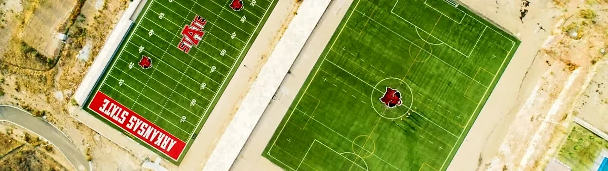 Vista panorámica del campo de fútbol americano y la cancha de soccer con pasto sintético de Arkansas State University, Campus Querétaro