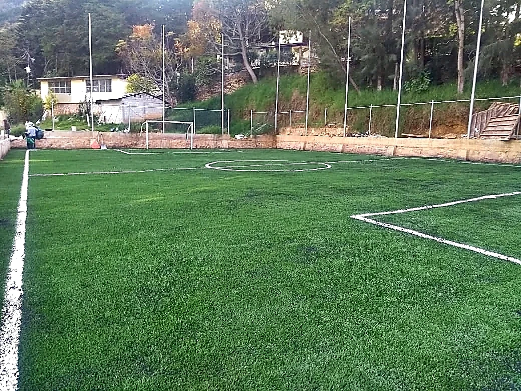 Cancha de fútbol 5 con pasto sintético en Telesecundaria Escudo Nacional, Pinal de Amoles, Querétaro: líneas insertadas en el pasto sintético
