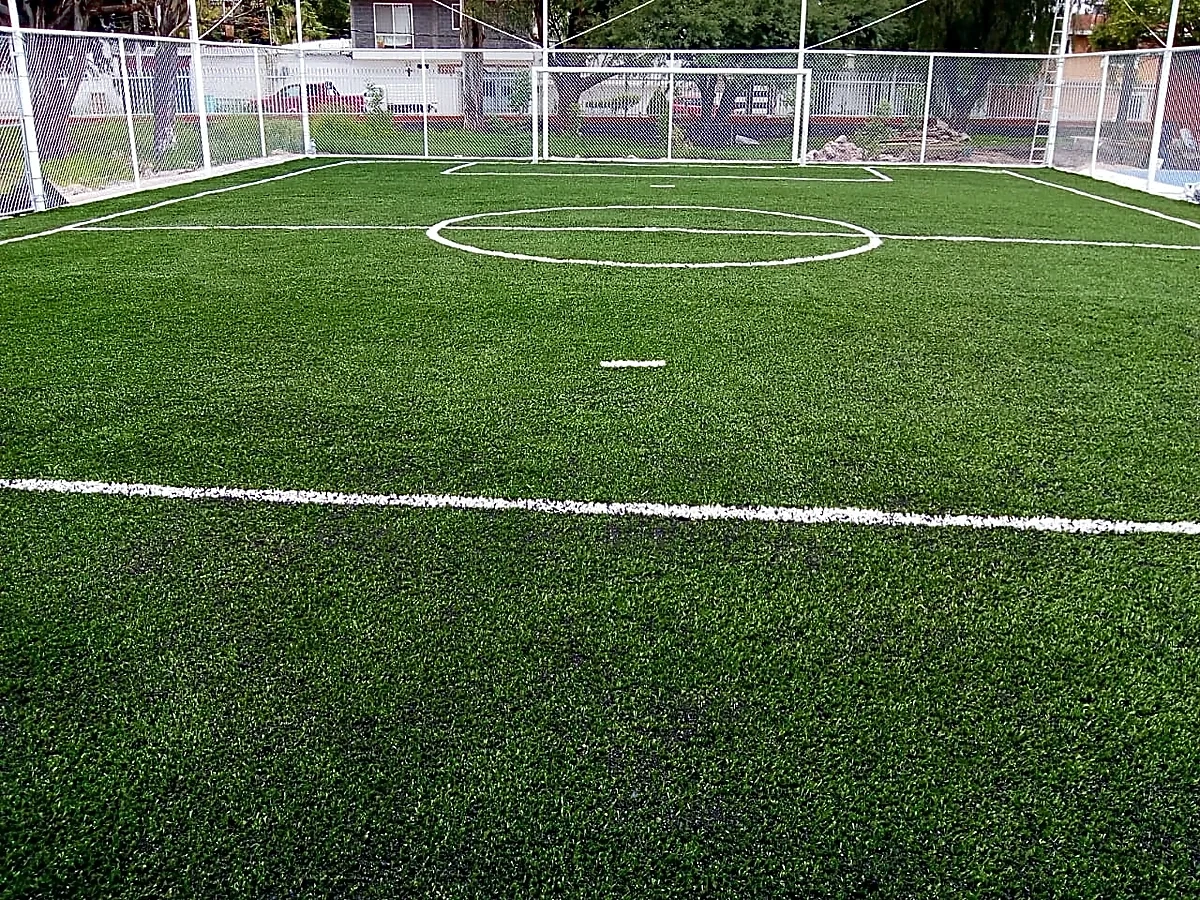 Cancha de fútbol 7 con pasto sintético en Escuela Primaria Melchor Ocampo, Querétaro, Querétaro: la cancha desde la línea lateral