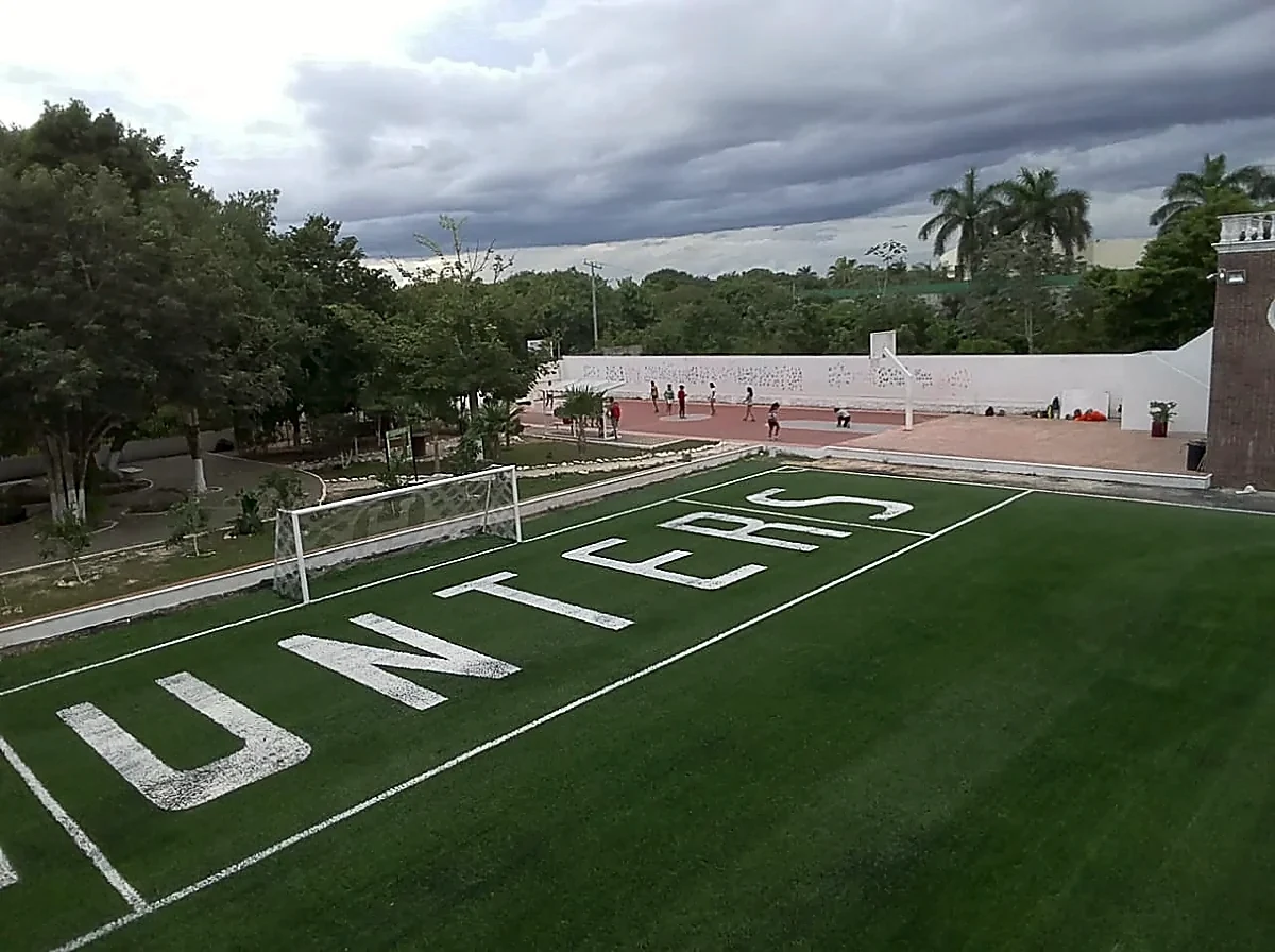 Campo de fútbol americano con pasto sintético en el Colegio Álamos, Cancún