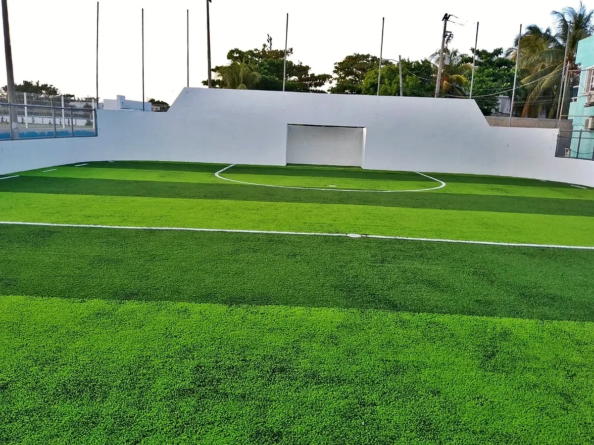 Cancha de fútbol rápido con pasto sintético en Multideportivo Salina Chica, Isla Mujeres, Quintana Roo: la cancha desde la línea lateral