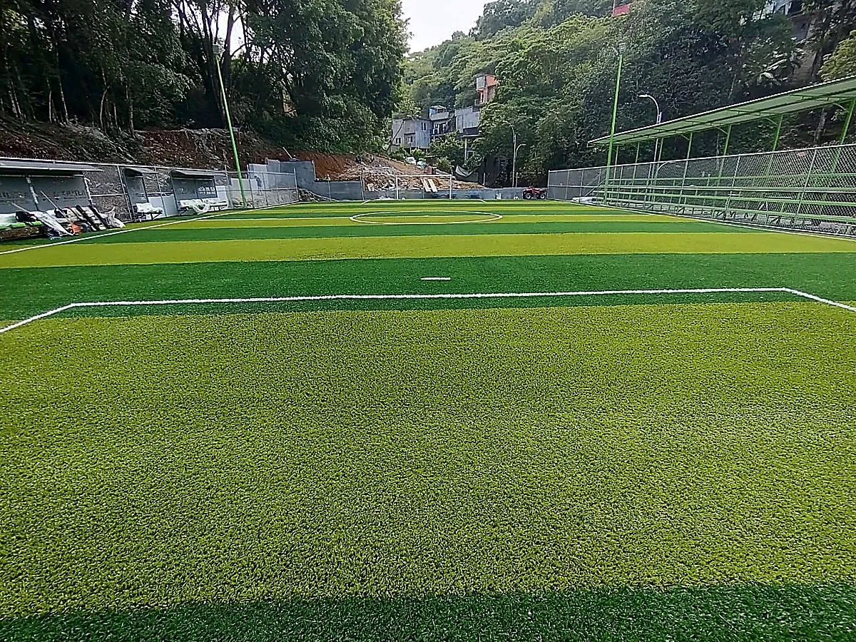 Cancha de fútbol 7 con pasto sintético en Unidad Deportiva de Xilitla, San Luis Potosí: la cancha desde la línea lateral