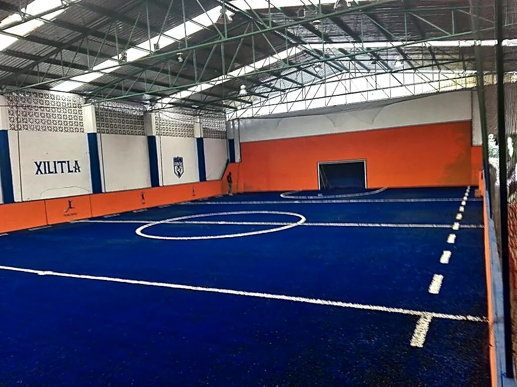 Cancha de fútbol rápido con pasto sintético en Cancha Cozolitos (pasto azul), Xilitla, San Luis Potosí: la cancha desde la línea lateral