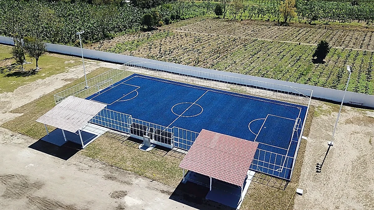 Cancha de fútbol 7 con pasto sintético en Área Recreativa Unidad y Compromiso (pasto azul), Villahermosa, Tabasco: la cancha desde la línea lateral