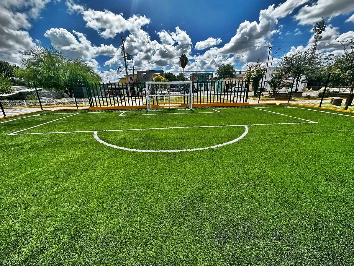 Cancha de fútbol 5 con pasto sintético en Plaza Pública la Libertad, Nuevo Laredo, Tamaulipas: la cancha desde la línea lateral