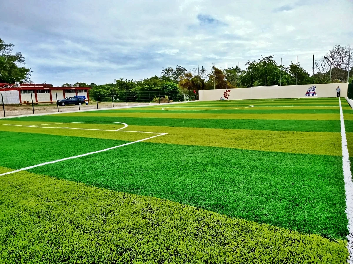 Cancha de fútbol 7 con pasto sintético en CETIS 22, Tampico, Tamaulipas: líneas de juego insertadas en el mismo pasto