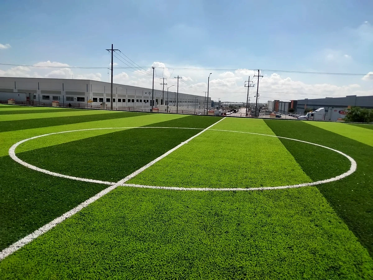 Cancha de fútbol 7 con pasto sintético en Empresa EMERSON, Reynosa, Tamaulipas: la cancha desde la línea lateral