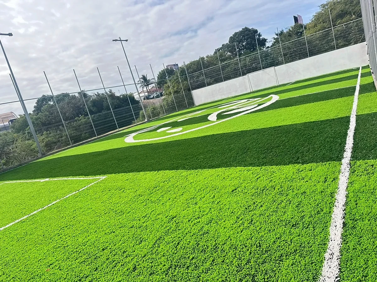 Cancha de fútbol 7 con pasto sintético a franjas y logotipo integrado en la UNE, Tampico