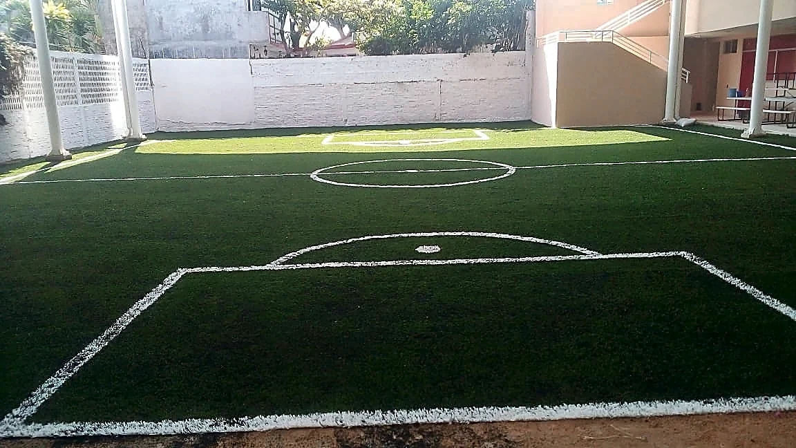 Cancha de fútbol 5 con pasto sintético en Colegio Americano, Poza Rica, Veracruz: líneas insertadas en el pasto sintético