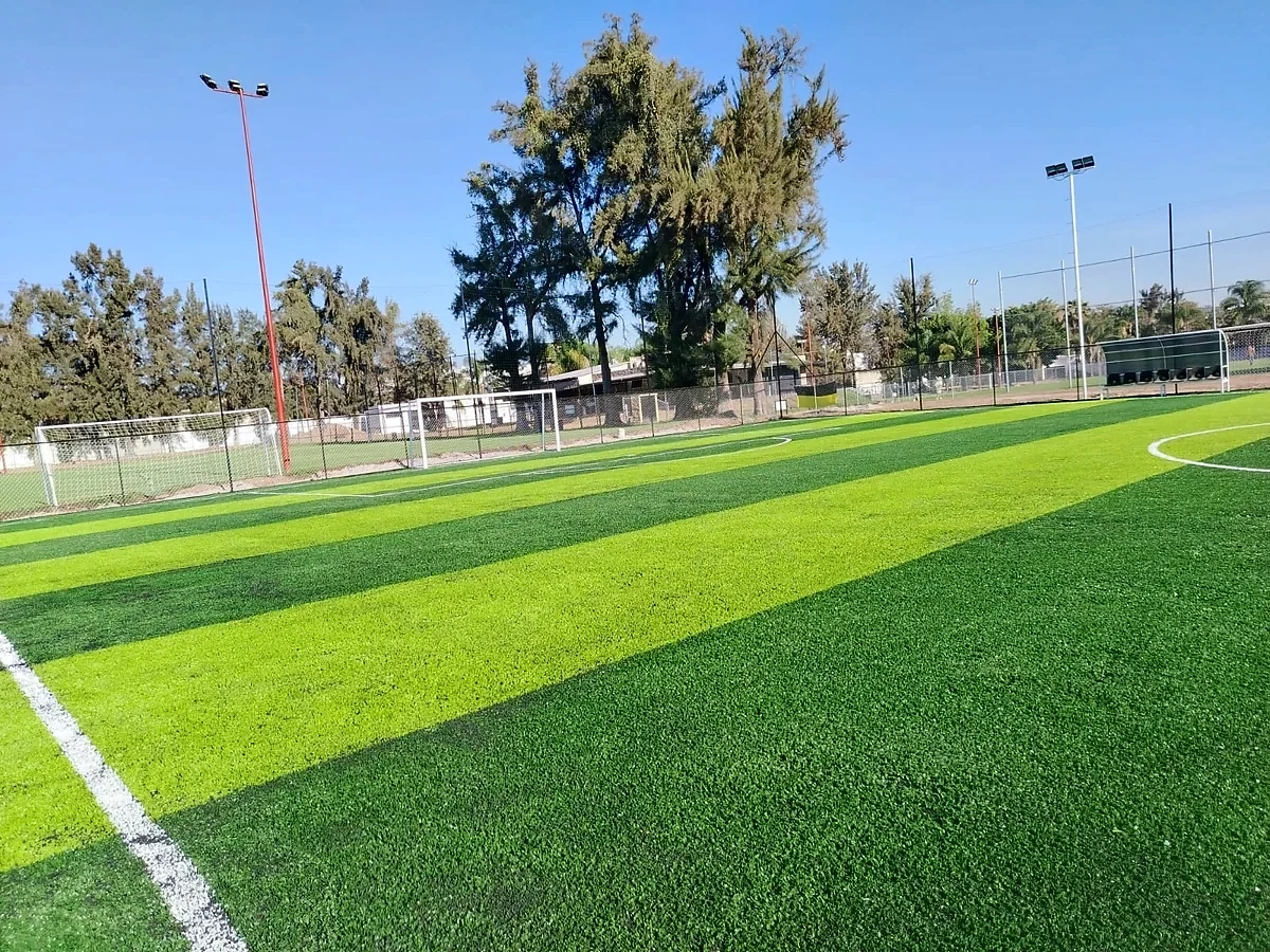 Canchas de fútbol 7 con pasto sintético, porterías y postes de iluminación en el Club Atlético Balam, Zapopan